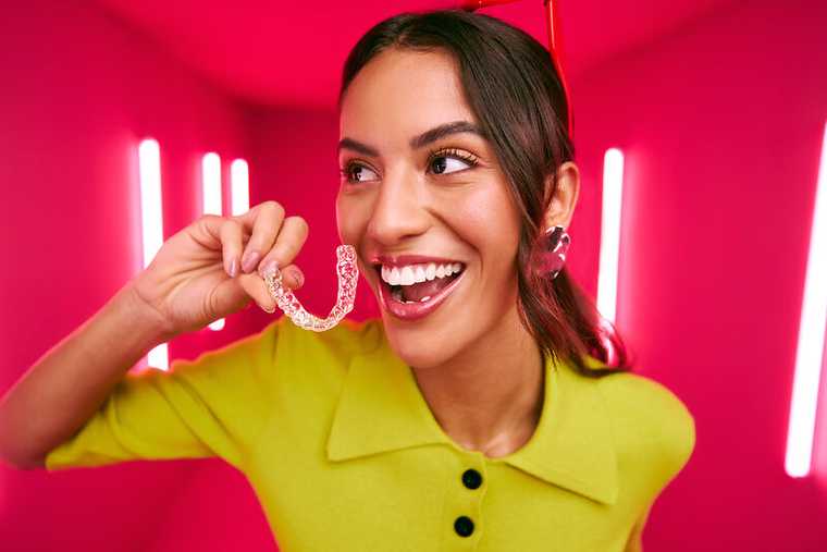 [CRO] Women - Brunette - Green - Shirt - Aligners - Looking right - Pink - Light - Background - Desktop