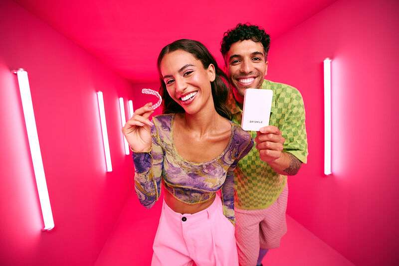 [CRO] Woman - Man - Brunettes - Colorfull clothes - Case - Aligner - Smile - Standing - Looking to the camera - Pink - Light - Background - Desktop